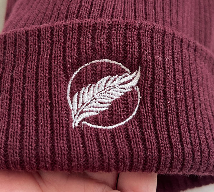 Roho Rafiki® embroidered icon organic cotton beanie. Crafted from 100% organically-sourced Control Union Certified cotton, this lightweight design in a heritage-inspired fine rib is the perfect all-year-round option for casual headwear. Embroidered with the white feather icon logo. A range of colours are available. A range of colours are available.
