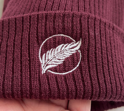 Roho Rafiki® embroidered icon organic cotton beanie. Crafted from 100% organically-sourced Control Union Certified cotton, this lightweight design in a heritage-inspired fine rib is the perfect all-year-round option for casual headwear. Embroidered with the white feather icon logo. A range of colours are available. A range of colours are available.