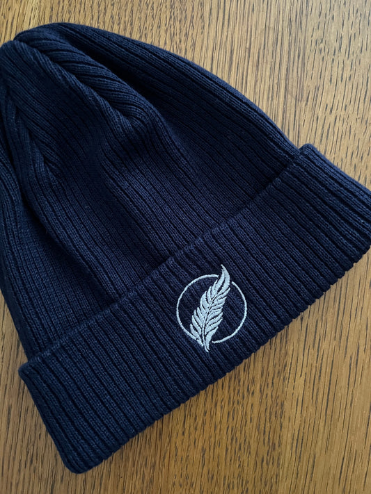 Roho Rafiki® embroidered icon organic cotton beanie. Crafted from 100% organically-sourced Control Union Certified cotton, this lightweight design in a heritage-inspired fine rib is the perfect all-year-round option for casual headwear. Embroidered with the white feather icon logo. Oxford Blue.